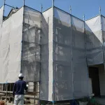 メッシュシートで覆われた塗装工事中の住宅（イメージ）