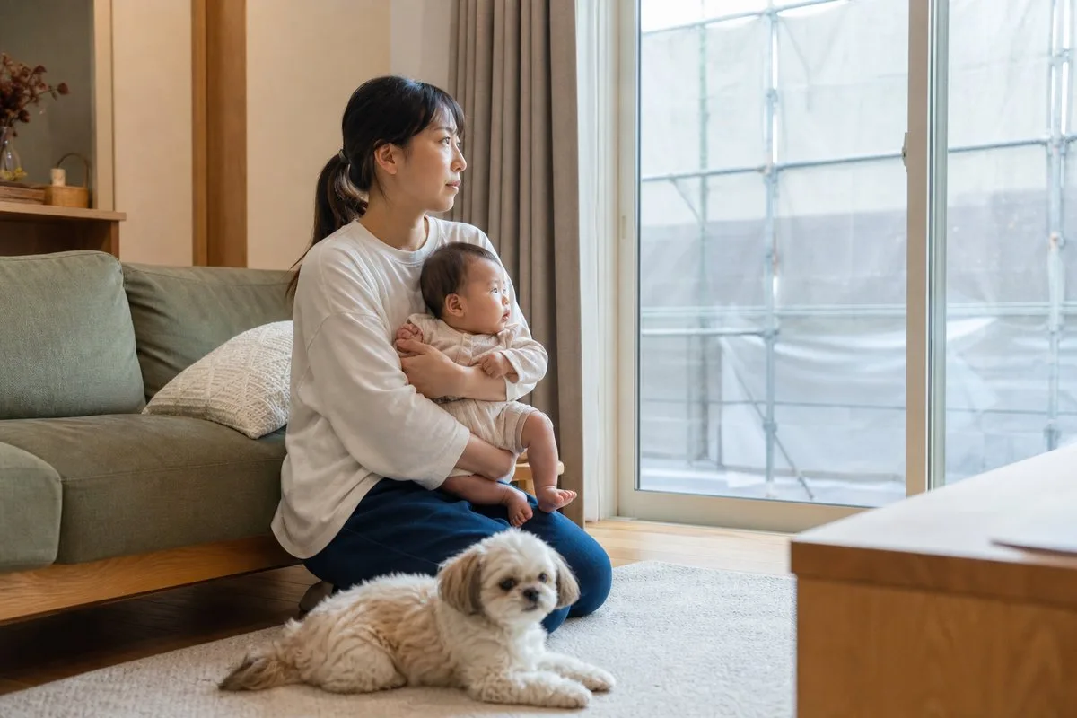 赤ちゃんとペットと過ごすリビング。窓の外に塗装工事の足場（イメージ）