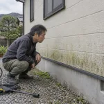 北側の外壁のコケを見つめる男性と、使う前の家庭用高圧洗浄機（イメージ）